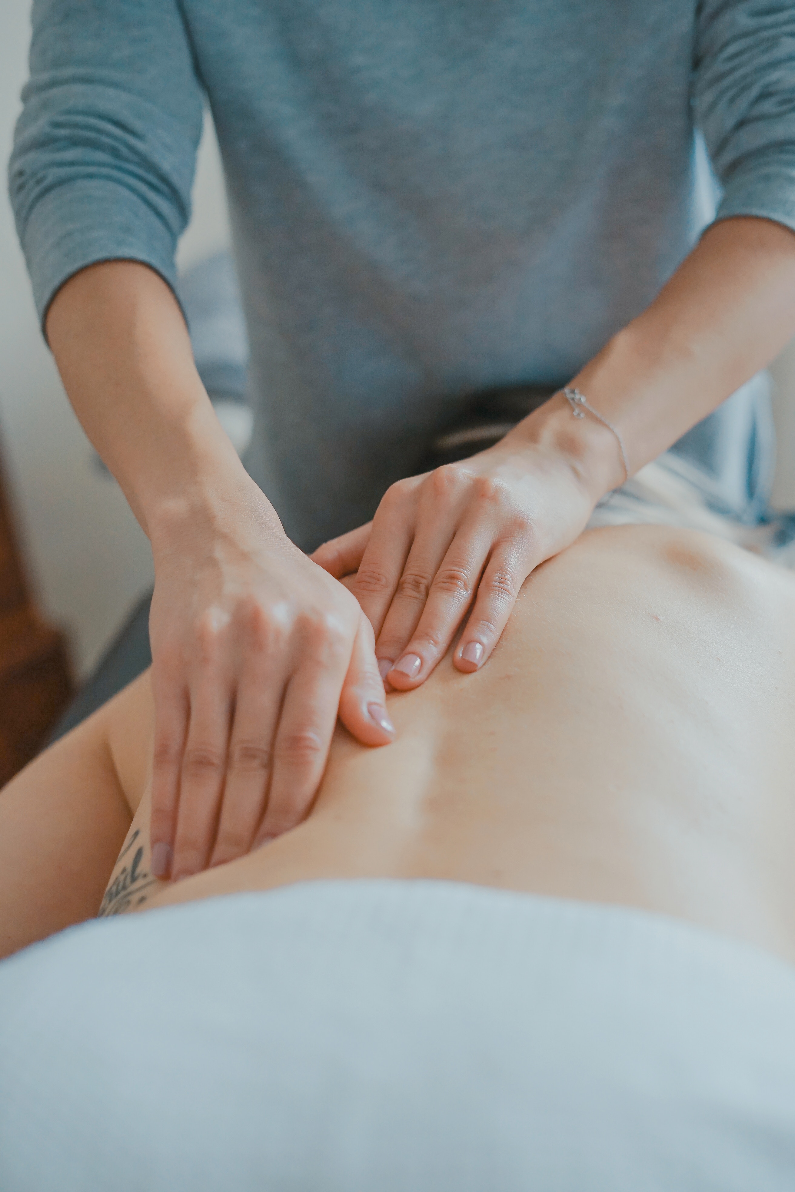 mains qui massent un dos en formation, selon les principes du massage californien