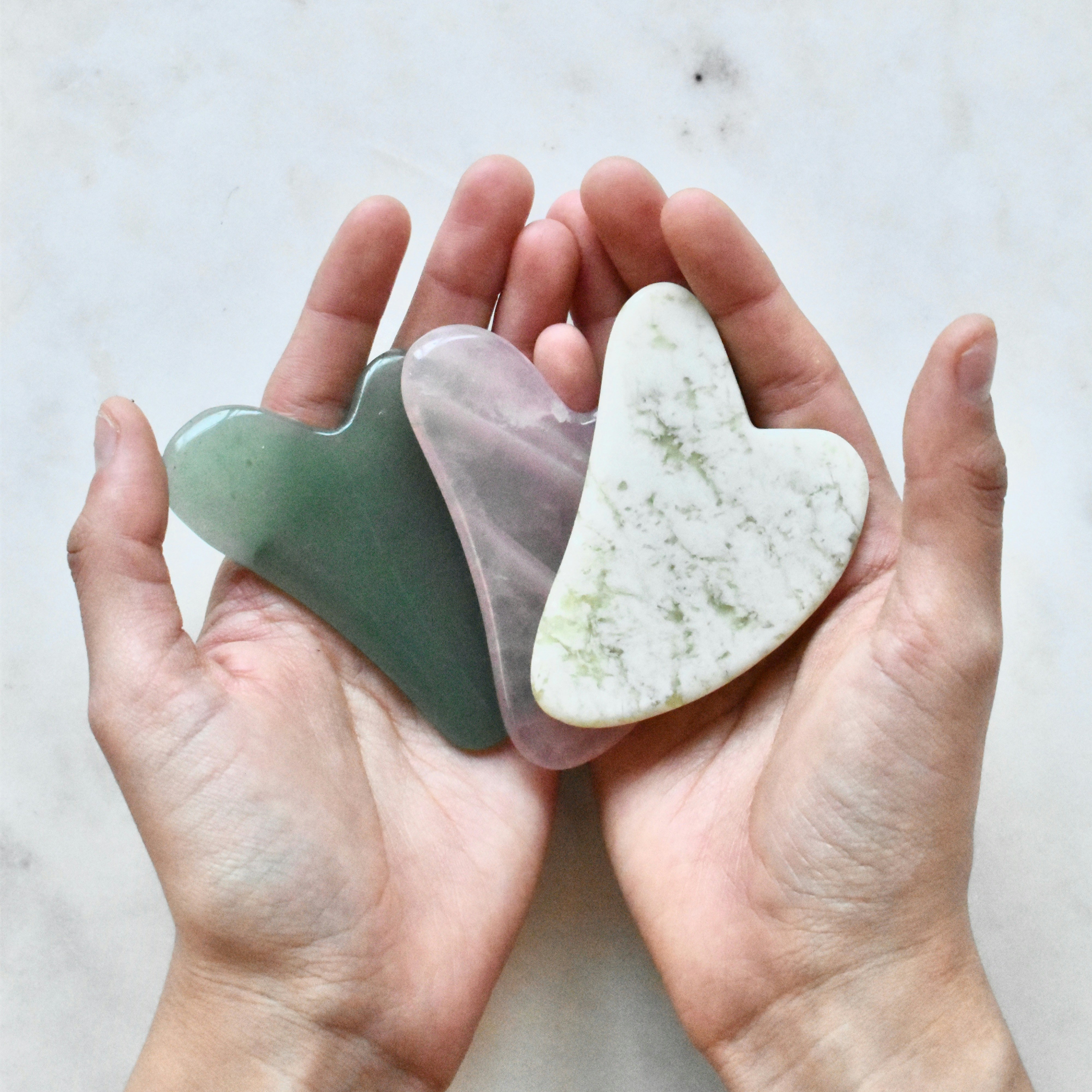 Mains tenant des Gua Sha de massage visage pour une formation en Bretagne